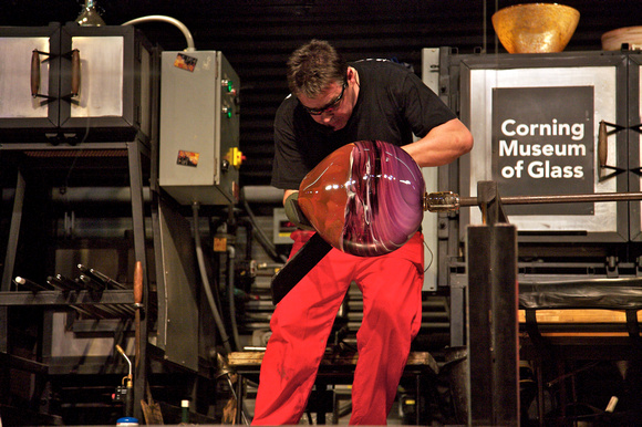 Shaw demonstrating glass blowing on the Corning mobile hot shop