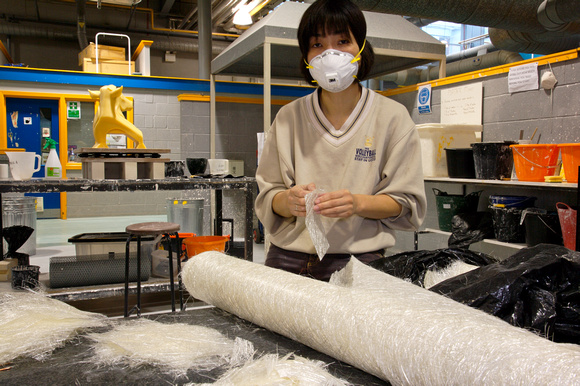Midori assisting with the preparation of fiber glass matting for inclusion into mould mix